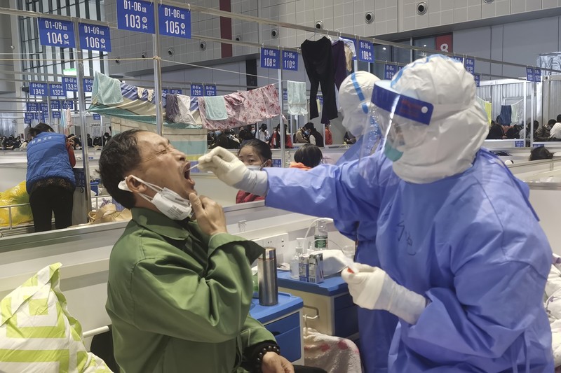 Petugas medis memindahkan seorang pasien dari ambulans di Rumah Sakit Minhang yang berafiliasi dengan Universitas Fudan di Shanghai. (AP/Zhang Jiansong)