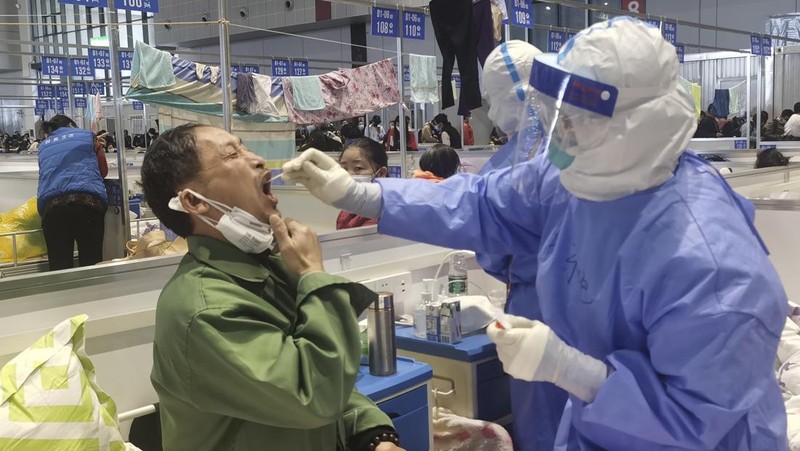 Petugas medis memindahkan seorang pasien dari ambulans di Rumah Sakit Minhang yang berafiliasi dengan Universitas Fudan di Shanghai. (AP/Zhang Jiansong)