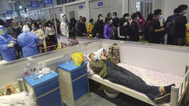 Petugas medis memindahkan seorang pasien dari ambulans di Rumah Sakit Minhang yang berafiliasi dengan Universitas Fudan di Shanghai. (AP/Zhang Jiansong)