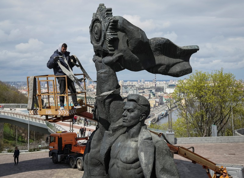 Pekerja membongkar monumen Soviet untuk persahabatan Ukraina-Rusia, di tengah invasi Rusia ke Ukraina. (REUTERS/GLEB GARANICH)