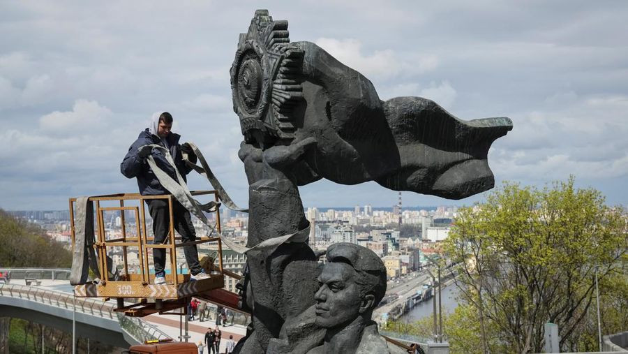 Pekerja membongkar monumen Soviet untuk persahabatan Ukraina-Rusia, di tengah invasi Rusia ke Ukraina. (REUTERS/GLEB GARANICH)