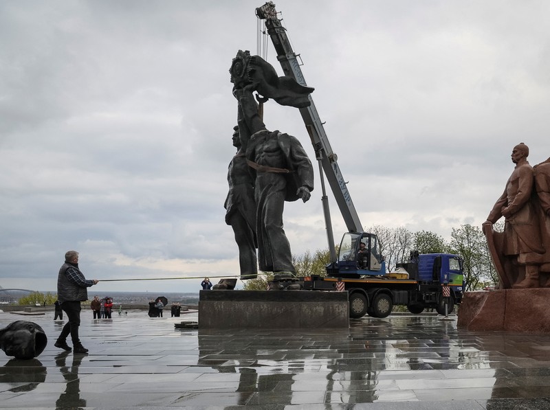 Pekerja membongkar monumen Soviet untuk persahabatan Ukraina-Rusia, di tengah invasi Rusia ke Ukraina. (REUTERS/GLEB GARANICH)