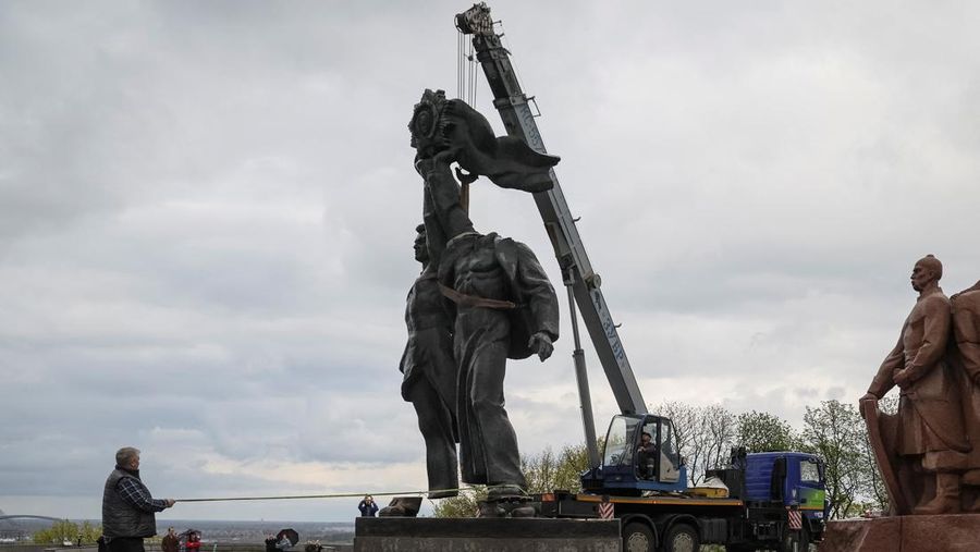 Pekerja membongkar monumen Soviet untuk persahabatan Ukraina-Rusia, di tengah invasi Rusia ke Ukraina. (REUTERS/GLEB GARANICH)