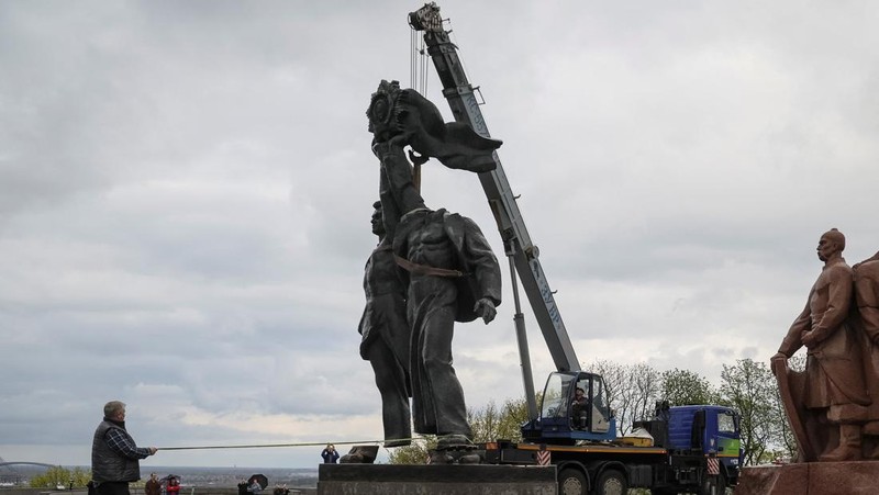 Pekerja membongkar monumen Soviet untuk persahabatan Ukraina-Rusia, di tengah invasi Rusia ke Ukraina. (REUTERS/GLEB GARANICH)