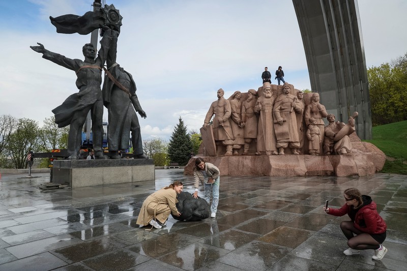 Pekerja membongkar monumen Soviet untuk persahabatan Ukraina-Rusia, di tengah invasi Rusia ke Ukraina. (REUTERS/GLEB GARANICH)