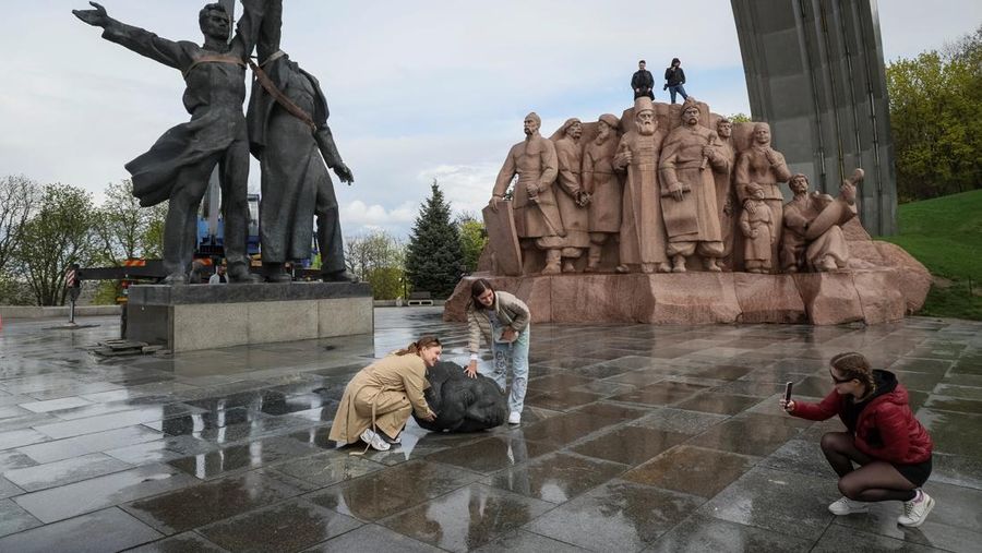 Pekerja membongkar monumen Soviet untuk persahabatan Ukraina-Rusia, di tengah invasi Rusia ke Ukraina. (REUTERS/GLEB GARANICH)