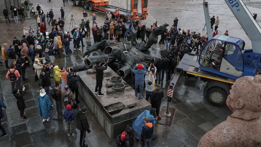 Pekerja membongkar monumen Soviet untuk persahabatan Ukraina-Rusia, di tengah invasi Rusia ke Ukraina. (REUTERS/GLEB GARANICH)
