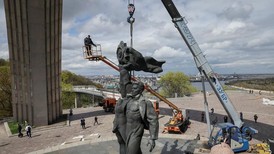 Pekerja membongkar monumen Soviet untuk persahabatan Ukraina-Rusia, di tengah invasi Rusia ke Ukraina. (REUTERS/GLEB GARANICH)