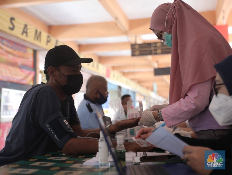 Petugas Badan Narkotika Nasional (BNN) bersama anjing pelacak K9 memeriksa barang pemudik di Terminal Kampung Rambutan, Jakarta, Rabu (27/4/2022). (CNBC Indonesia/Muhammad Sabki)