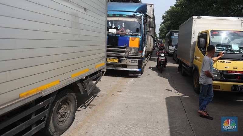 Pengendara beritirahat di depan mobilnya saat mengalami kemacetan di kawasan BIC, Bungursari, Purwakarta, Jumat (29/4/2021). Imbas diberlakukannya one way sejumlah ruas mengalami kemacetan salah satunya dari kawasan BIC, Bungursari ke arah Cikopo. (CNBC Indonesia/Andrean Kristianto)