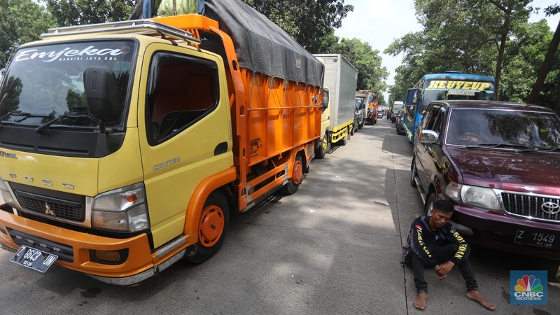 Pengendara beritirahat di depan mobilnya saat mengalami kemacetan di kawasan BIC, Bungursari, Purwakarta, Jumat (29/4/2021). Imbas diberlakukannya one way sejumlah ruas mengalami kemacetan salah satunya dari kawasan BIC, Bungursari ke arah Cikopo. (CNBC Indonesia/Andrean Kristianto)