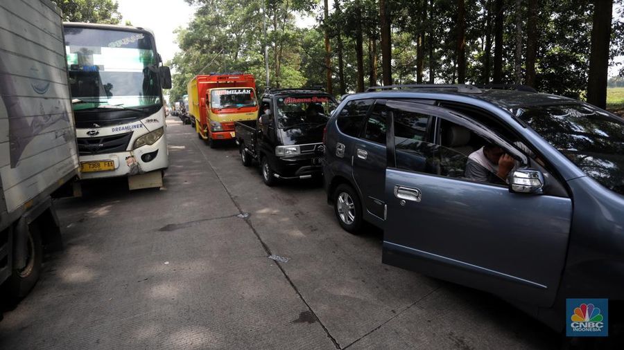 Pengendara beritirahat di depan mobilnya saat mengalami kemacetan di kawasan BIC, Bungursari, Purwakarta, Jumat (29/4/2021). Imbas diberlakukannya one way sejumlah ruas mengalami kemacetan salah satunya dari kawasan BIC, Bungursari ke arah Cikopo. (CNBC Indonesia/Andrean Kristianto)