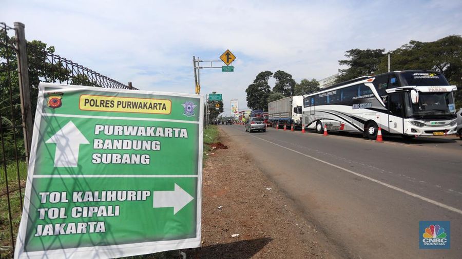 Pengendara beritirahat di depan mobilnya saat mengalami kemacetan di kawasan BIC, Bungursari, Purwakarta, Jumat (29/4/2021). Imbas diberlakukannya one way sejumlah ruas mengalami kemacetan salah satunya dari kawasan BIC, Bungursari ke arah Cikopo. (CNBC Indonesia/Andrean Kristianto)
