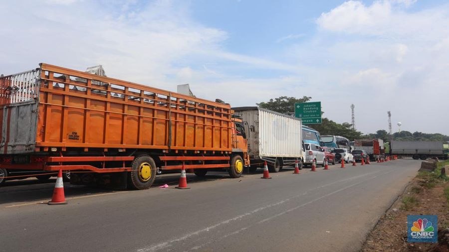Pengendara beritirahat di depan mobilnya saat mengalami kemacetan di kawasan BIC, Bungursari, Purwakarta, Jumat (29/4/2021). Imbas diberlakukannya one way sejumlah ruas mengalami kemacetan salah satunya dari kawasan BIC, Bungursari ke arah Cikopo. (CNBC Indonesia/Andrean Kristianto)