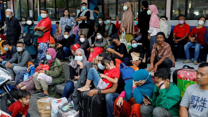 People wait for buses at Kampung Rambutan bus terminal, as Indonesian Muslims travel home to celebrate Eid al-Fitr, known locally as 'Mudik', in Jakarta, Indonesia, April 29, 2022. REUTERS/Willy Kurniawan     TPX IMAGES OF THE DAY