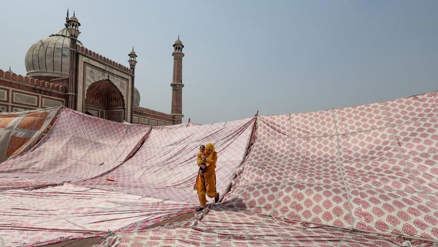 A Muslim woman with a child leaves after offering prayers during Jumat-ul-Vida or the last Friday of the holy fasting month of Ramadan, at Jama Masjid in the old quarters of Delhi, India, April 29, 2022. REUTERS/Anushree Fadnavis TPX IMAGES OF THE DAY