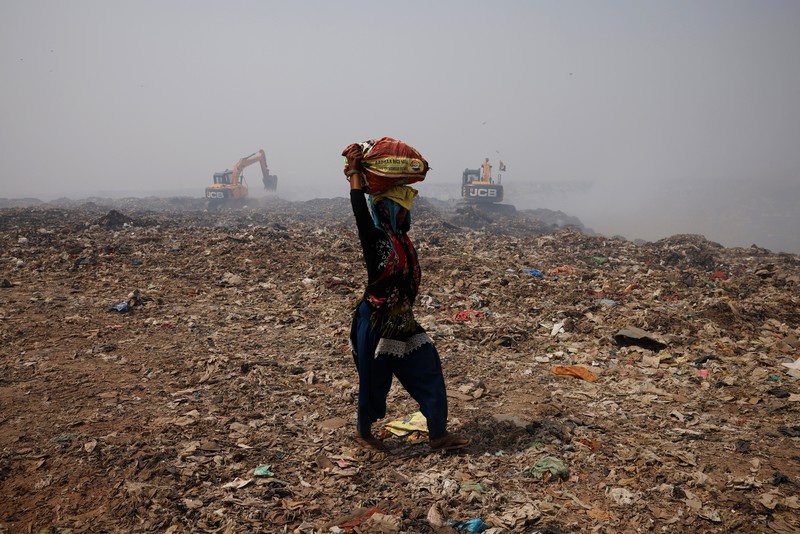 SOUTHASIA-WEATHER/HEATWAVE An excavator tries to contain the fire as smoke billows from burning garbage on a hot summer day, at the Bhalswa landfill site in New Delhi, India, April 29, 2022. REUTERS/Adnan Abidi TPX IMAGES OF THE DAY