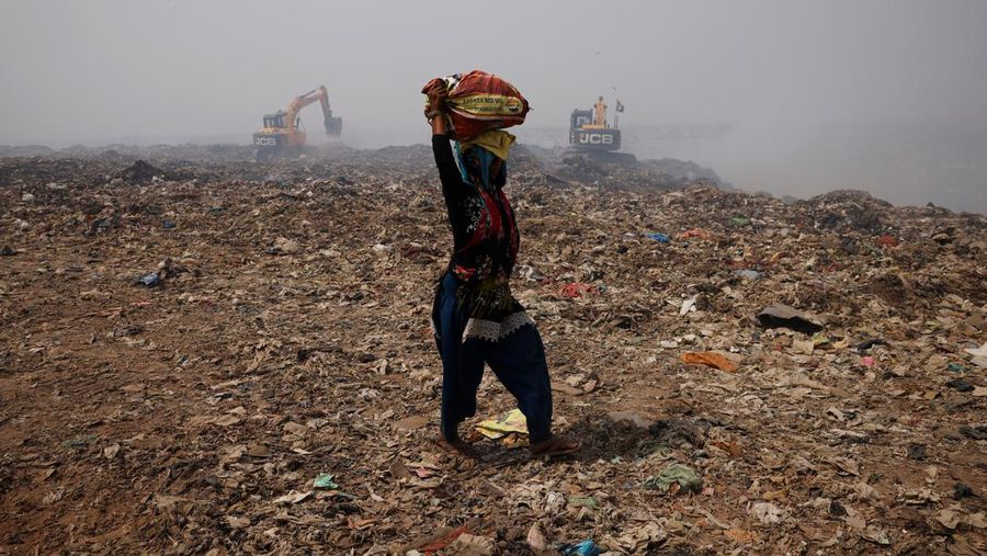 An excavator tries to contain the fire as smoke billows from burning garbage on a hot summer day, at the Bhalswa landfill site in New Delhi, India, April 29, 2022. REUTERS/Adnan Abidi     TPX IMAGES OF THE DAY
