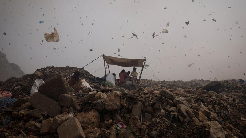 An excavator tries to contain the fire as smoke billows from burning garbage on a hot summer day, at the Bhalswa landfill site in New Delhi, India, April 29, 2022. REUTERS/Adnan Abidi     TPX IMAGES OF THE DAY