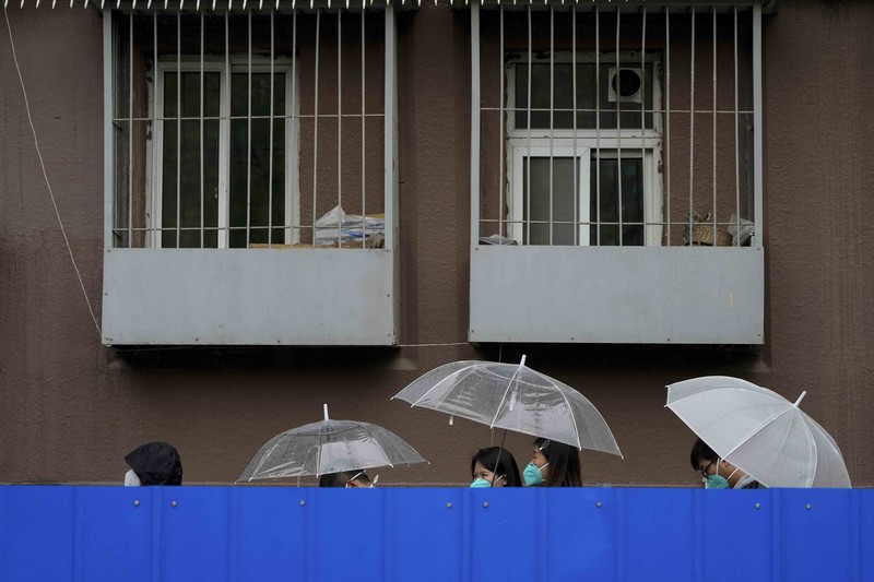 Virus Outbreak China Barriers Explainer A resident wearing a face mask stands watch behind a barricaded fence of a locked-down residential complex on Thursday, April 28, 2022, in Beijing. China employs a variety of metal barricades, metal sheeting and door locks to keep people inside their apartments, buildings or complexes during lockdowns. The barriers have been deployed in multiple cities across China as part of the fight against COVID-19. (AP Photo/Andy Wong)