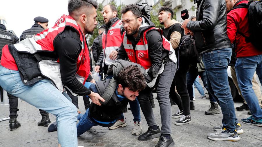 Petugas kepolisian menahan seorang pengunjuk rasa yang menggelar unjuk rasa May Day di Lapangan Taksim di Istanbul, Turki, Minggu (1/5/2022). (REUTERS/Kemal Aslan)