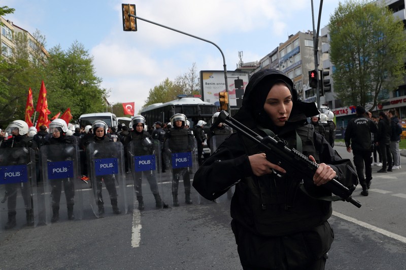 Petugas kepolisian menahan seorang pengunjuk rasa yang menggelar unjuk rasa May Day di Lapangan Taksim di Istanbul, Turki, Minggu (1/5/2022). (REUTERS/Kemal Aslan)