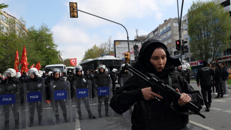Petugas kepolisian menahan seorang pengunjuk rasa yang menggelar unjuk rasa May Day di Lapangan Taksim di Istanbul, Turki, Minggu (1/5/2022). (REUTERS/Kemal Aslan)