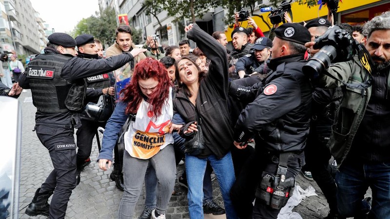 Petugas kepolisian menahan seorang pengunjuk rasa yang menggelar unjuk rasa May Day di Lapangan Taksim di Istanbul, Turki, Minggu (1/5/2022). (REUTERS/Kemal Aslan)