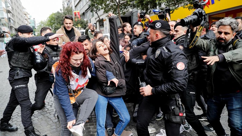 Petugas kepolisian menahan seorang pengunjuk rasa yang menggelar unjuk rasa May Day di Lapangan Taksim di Istanbul, Turki, Minggu (1/5/2022). (REUTERS/Kemal Aslan)