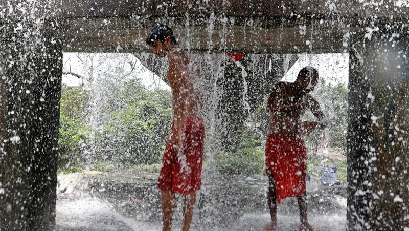 Orang-orang mandi saat cuaca panas di Kolkata, India, Senin (2/5/2022). (REUTERS/Rupak De Chowdhuri)