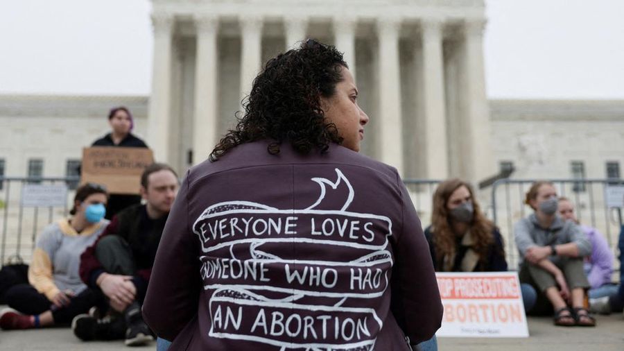 Pengunjuk rasa Renee Bracey Sherman duduk di luar Mahkamah Agung AS setelah bocornya draf pendapat mayoritas yang ditulis oleh Hakim Samuel Alito yang mempersiapkan mayoritas pengadilan untuk membatalkan keputusan penting hak aborsi Roe v. Wade akhir tahun ini, di Washington, AS, Selasa (3/5/2022). (REUTERS/Evelyn Hockstein)