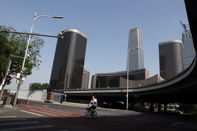Penguncian Lockdown Covid-19 di Beijing China Warga mengendarai sepeda di Central Business District (CBD) saat pemerintah menerapkan perintah kerja dari rumah bagi penduduk distrik Chaoyang di tengah wabah penyakit coronavirus (COVID-19), di Beijing, China, Kamis (5/4/2022). (REUTERS/Tingshu Wang)