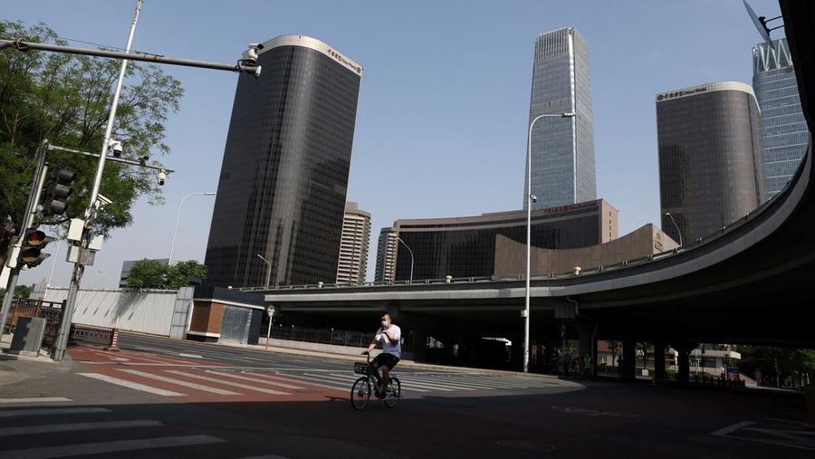 Seorang pria mengendarai sepeda di Central Business District (CBD) saat pemerintah menerapkan perintah kerja dari rumah bagi penduduk distrik Chaoyang di tengah wabah penyakit coronavirus (COVID-19), di Beijing, China, Kamis (5/4/2022). (REUTERS/Tingshu Wang)