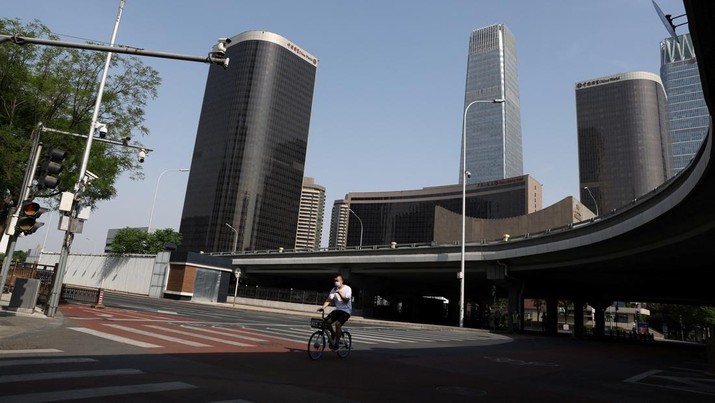 Penguncian Lockdown Covid-19 di Beijing China Seorang pria mengendarai sepeda di Central Business District (CBD) saat pemerintah menerapkan perintah kerja dari rumah bagi penduduk distrik Chaoyang di tengah wabah penyakit coronavirus (COVID-19), di Beijing, China, Kamis (5/4/2022). (REUTERS/Tingshu Wang)