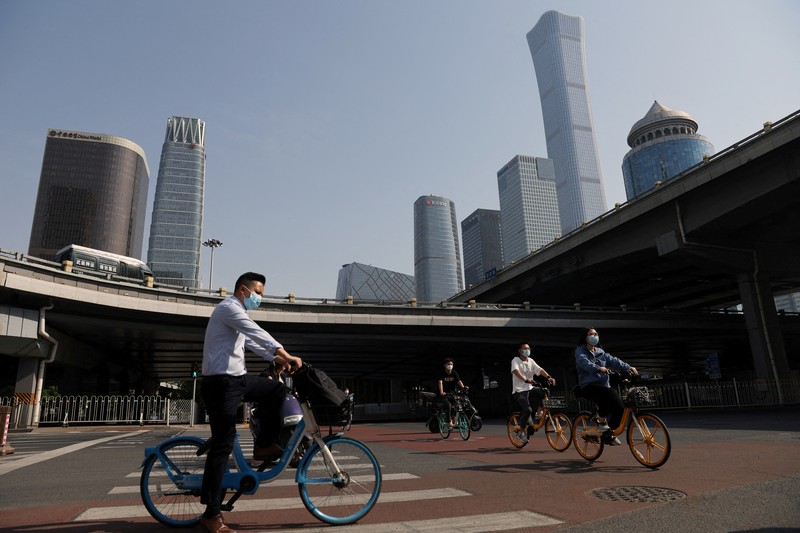 Warga mengendarai sepeda di Central Business District (CBD) saat pemerintah menerapkan perintah kerja dari rumah bagi penduduk distrik Chaoyang di tengah wabah penyakit coronavirus (COVID-19), di Beijing, China, Kamis (5/4/2022). (REUTERS/Tingshu Wang)