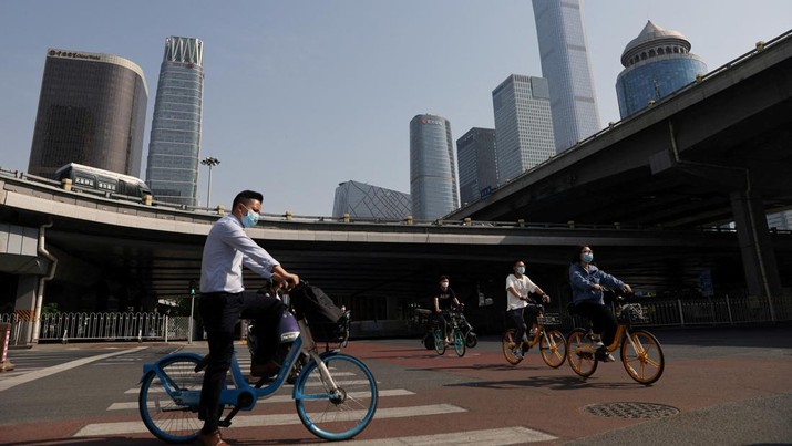 Warga mengendarai sepeda di Central Business District (CBD) saat pemerintah menerapkan perintah kerja dari rumah bagi penduduk distrik Chaoyang di tengah wabah penyakit coronavirus (COVID-19), di Beijing, China, Kamis (5/4/2022). (REUTERS/Tingshu Wang)