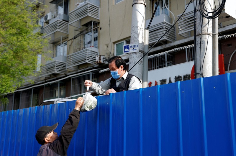 Warga mengendarai sepeda di Central Business District (CBD) saat pemerintah menerapkan perintah kerja dari rumah bagi penduduk distrik Chaoyang di tengah wabah penyakit coronavirus (COVID-19), di Beijing, China, Kamis (5/4/2022). (REUTERS/Tingshu Wang)