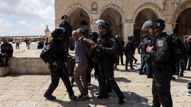 Pasukan keamanan Israel berjaga di dekat sebuah pintu di kompleks Masjid Al-Aqsa di Kota Tua Yerusalem, Kamis (5/4/2022). (REUTERS/Ammar Awad)