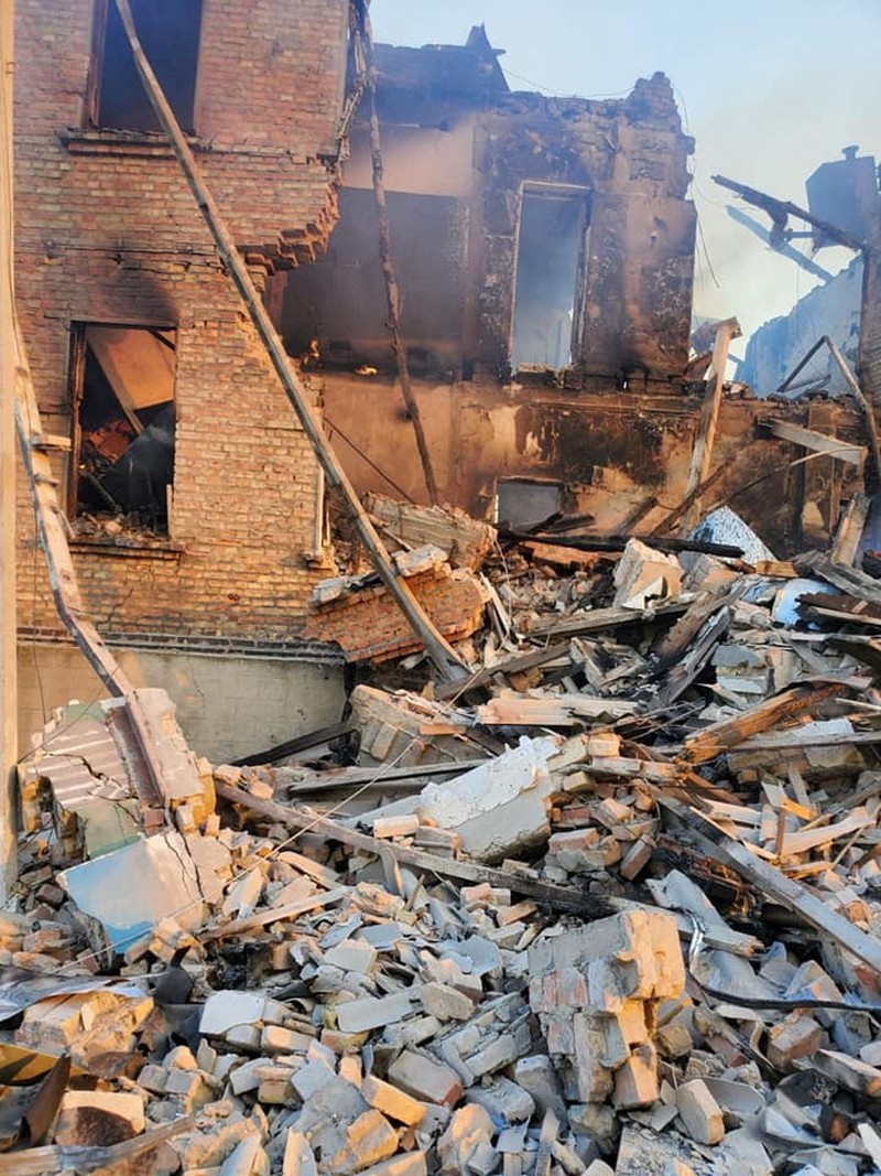 Petugas pemadam kebakaran bekerja di dekat puing-puing yang terbakar, setelah sebuah gedung sekolah hancur akibat bom yang dilakukan oleh Rusia di desa Bilohorivka, Luhansk, Ukraina, Minggu (8/5/2022). (Luhansk Regional Military-Civil Administration/Handout via REUTERS)