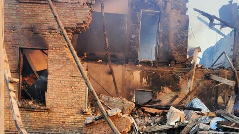 Petugas pemadam kebakaran bekerja di dekat puing-puing yang terbakar, setelah sebuah gedung sekolah hancur akibat bom yang dilakukan oleh Rusia di desa Bilohorivka, Luhansk, Ukraina, Minggu (8/5/2022). (Luhansk Regional Military-Civil Administration/Handout via REUTERS)