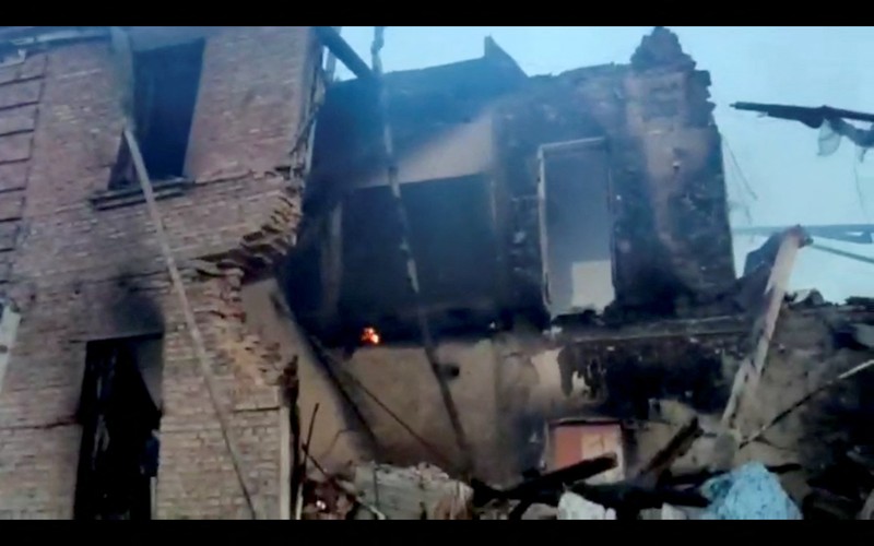 Petugas pemadam kebakaran bekerja di dekat puing-puing yang terbakar, setelah sebuah gedung sekolah hancur akibat bom yang dilakukan oleh Rusia di desa Bilohorivka, Luhansk, Ukraina, Minggu (8/5/2022). (Luhansk Regional Military-Civil Administration/Handout via REUTERS)