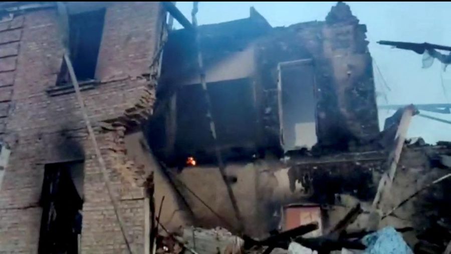 Petugas pemadam kebakaran bekerja di dekat puing-puing yang terbakar, setelah sebuah gedung sekolah hancur akibat bom yang dilakukan oleh Rusia di desa Bilohorivka, Luhansk, Ukraina, Minggu (8/5/2022). (Luhansk Regional Military-Civil Administration/Handout via REUTERS)