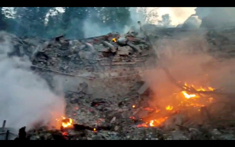 Petugas pemadam kebakaran bekerja di dekat puing-puing yang terbakar, setelah sebuah gedung sekolah hancur akibat bom yang dilakukan oleh Rusia di desa Bilohorivka, Luhansk, Ukraina, Minggu (8/5/2022). (Luhansk Regional Military-Civil Administration/Handout via REUTERS)