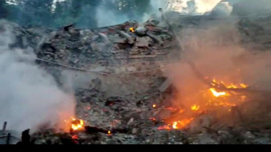 Api berkobar dekat puing bangunan sekolah yang hancur akibat bom yang dilakukan oleh Rusia di desa Bilohorivka, Luhansk, Ukraina, Minggu (8/5/2022). (Luhansk Regional Military-Civil Administration/Handout via REUTERS)