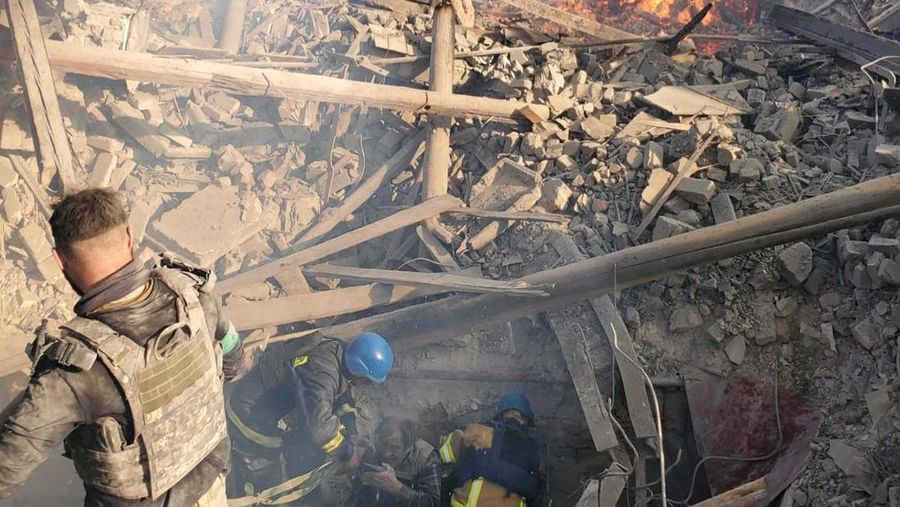 Petugas pemadam kebakaran bekerja di dekat puing-puing yang terbakar, setelah sebuah gedung sekolah hancur akibat bom yang dilakukan oleh Rusia di desa Bilohorivka, Luhansk, Ukraina, Minggu (8/5/2022). (Luhansk Regional Military-Civil Administration/Handout via REUTERS)