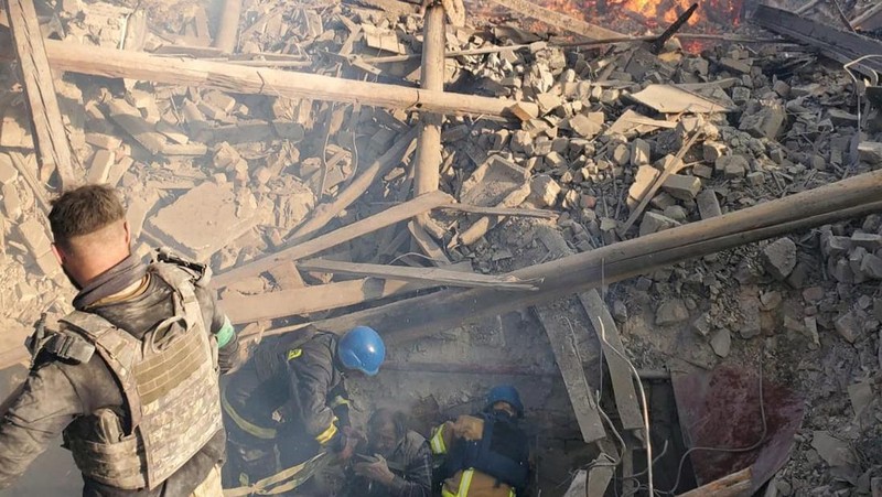 Petugas pemadam kebakaran bekerja di dekat puing-puing yang terbakar, setelah sebuah gedung sekolah hancur akibat bom yang dilakukan oleh Rusia di desa Bilohorivka, Luhansk, Ukraina, Minggu (8/5/2022). (Luhansk Regional Military-Civil Administration/Handout via REUTERS)