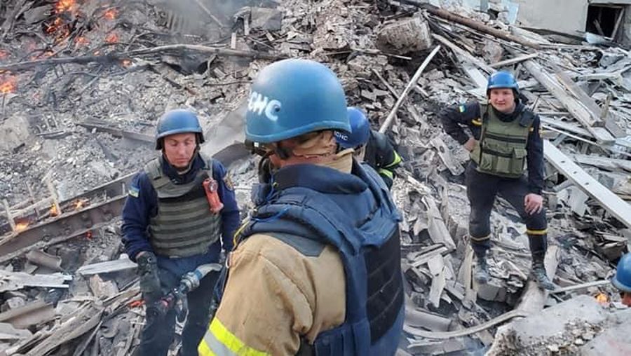 Petugas pemadam kebakaran bekerja di dekat puing-puing yang terbakar, setelah sebuah gedung sekolah hancur akibat bom yang dilakukan oleh Rusia di desa Bilohorivka, Luhansk, Ukraina, Minggu (8/5/2022). (Luhansk Regional Military-Civil Administration/Handout via REUTERS)