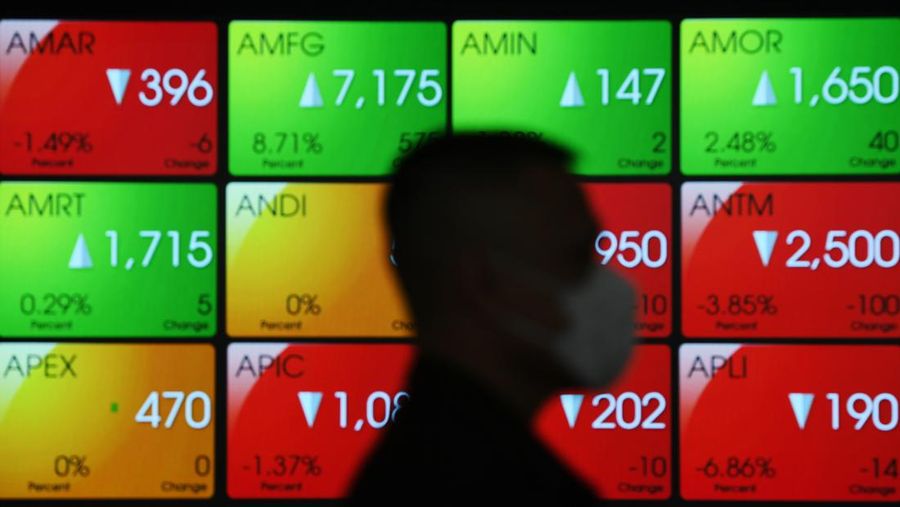 Pekerja melintas di depan layar yang menampilkan pergerakan Indeks Harga Saham Gabungan (IHSG) di Bursa Efek Indonesia, Jakarta, Senin (9/5/2022). IHSG ditutup melemah 4,42 persen atau 319,16 poin ke level 6.909,75 pada perdagangan bursa saham hari pertama usai libur Lebaran 2022. ANTARA FOTO/Hafidz Mubarak A/pras.