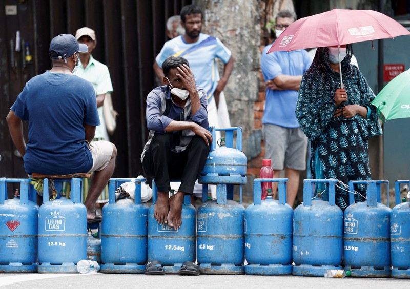 SRI LANKA-CRISIS/ People block a main road as they wait for the gas trucks to arrive at the station to distribute for them, amid the country's economic crisis in Colombo, Sri Lanka, May 8, 2022. REUTERS/Dinuka Liyanawatte