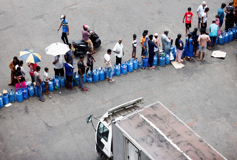 SRI LANKA-CRISIS/ People block a main road as they wait for the gas trucks to arrive at the station to distribute for them, amid the country's economic crisis in Colombo, Sri Lanka, May 8, 2022. REUTERS/Dinuka Liyanawatte